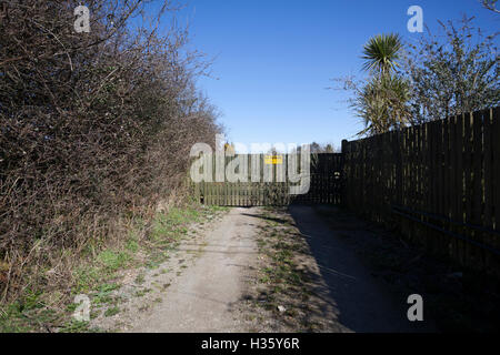 Sign on a large gate asking for no one to block the drive way. Stock Photo