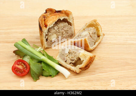 Pork pie and salad on a wooden chopping board Stock Photo