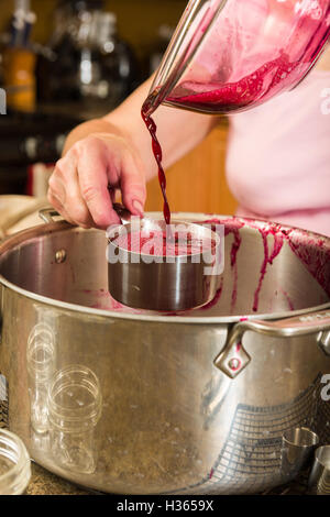 Juice being measured for addind sugar and pectin for the final step in making grape jam. Stock Photo