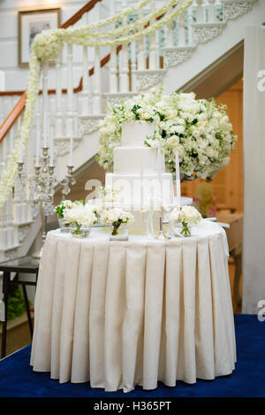 Wedding cake surrounded by white flowers Stock Photo