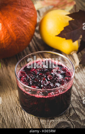 Homemade thanksgiving cranberry sauce in glass on woonen table Stock Photo