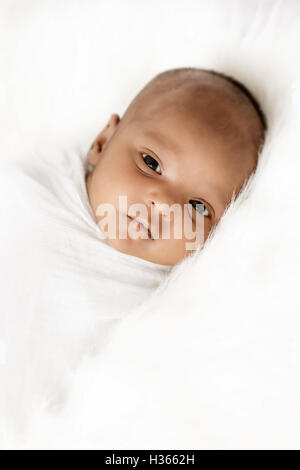 Three weeks old baby sleeping on white blanket cute infant newborn lying down close up shot eyes open
