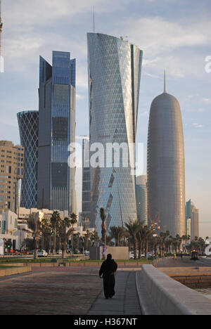 A lady taking an early morning stroll along the sea front wearing a hijab in Doha, Qatar. Stock Photo