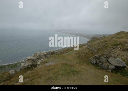 The view from the Quarry on the Isle of Portland overlooking Chesil beach, Weymouth in Dorset on a rainy misty day. Stock Photo