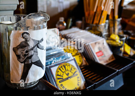 A tip jar pitcher with a photo of Elvis Presley attached sits on bar for visitors inside Sun Record Studios in Memphis, TN Stock Photo