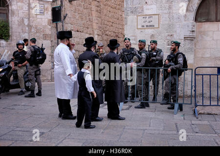 Ultra Orthodox Jews speak to members of the Israeli Security Forces standing guard in Via dolorosa street also called in Arabic Al Wad street in the Muslim Quarter Old city East Jerusalem Israel Stock Photo