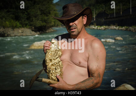 Gold Nugget mining from the River, with a gold pan, and find some big gold nugget. Stock Photo