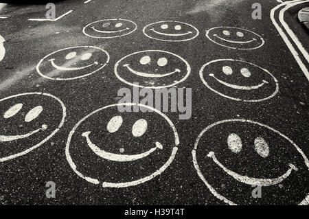 Smiley faces painted on a road Stock Photo