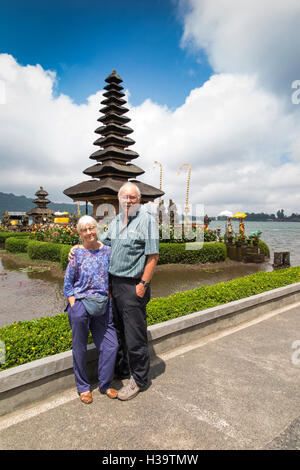 Indonesia, Bali, Candikuning Pura Ulun Danu Bratan temple, older tourists posing for picture at pagoda on lake Stock Photo