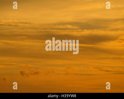 Beautiful golden after sunset cloudy sky, background Stock Photo