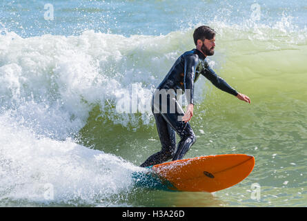 Man surfing on a surfboard on a wave at sea. Stock Photo
