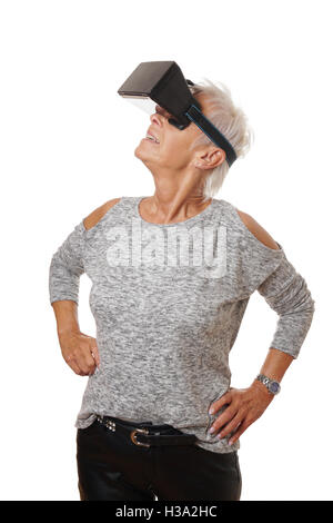 mature woman wearing VR headset experiencing virtual reality Stock Photo