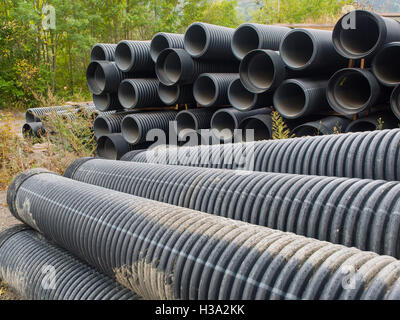 group of big plastic (Polyethylene) corrugated pipes stacked in a construction site Stock Photo