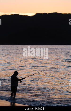 A tico fishes on a beach at Guancaste in Costa Rica at dusk. Stock Photo