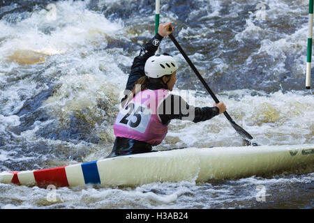 Female white water canoeist competing in the Canoe Wales National Slalom at the National White Water Centre on the River Tryweryn Frongoch North Wales Stock Photo