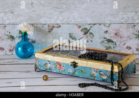 A stunning hand made jewelley box decoupaged and gilded on a rustic background Stock Photo