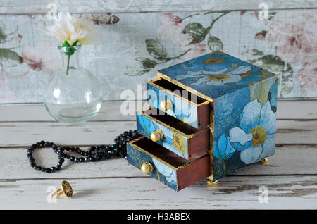 Beautiful hand made mini chest of drawers decoupaged in a blue floral design and gilded with gold leaf Stock Photo