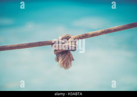 Rope with a knot on blue background Stock Photo