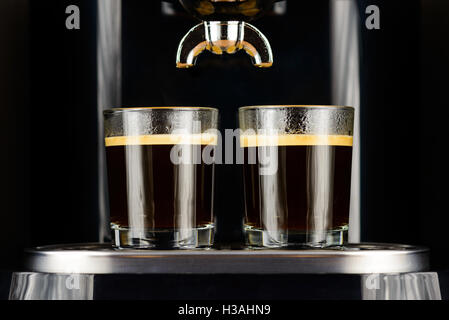 Two espresso coffees in glass cups on coffee machine Stock Photo