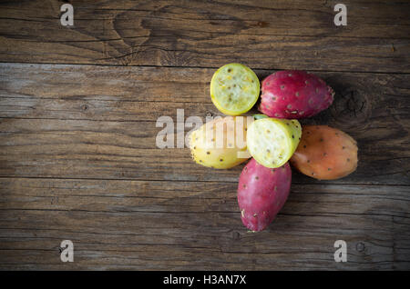 Colored and fresh prickly pears on wooden table Stock Photo