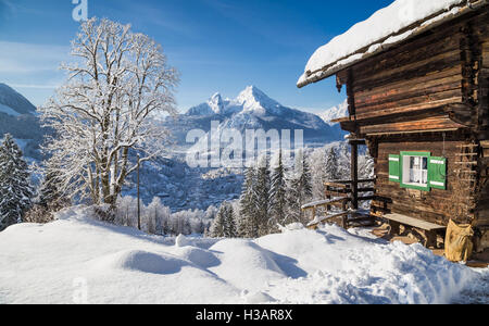 Winter wonderland mountain scenery in the Alps with traditional mountain chalet on a cold sunny day Stock Photo