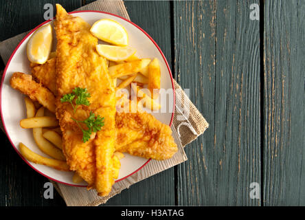 Close up of battered fish on a plate with chips Stock Photo