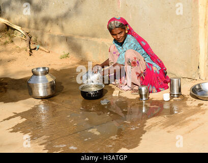 BHUJ, RAN OF KUCH, INDIA - JANUARY 13: The tribal woman in the village on the desert in the Gujarat state he is washing dishes
