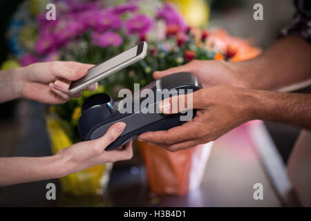 Hand of customer making payment through smartphone Stock Photo