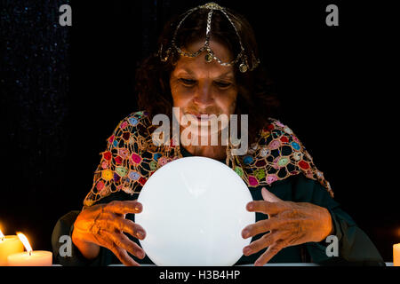 Mature fortune teller with crystal ball Stock Photo