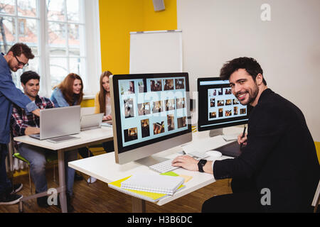 Smiling photo editor working on computer Stock Photo