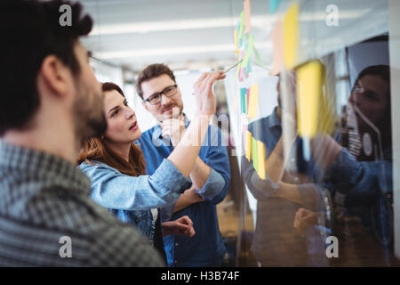 Businesswoman writing on sticky notes Stock Photo
