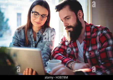 Couple using tablet at cafe Stock Photo