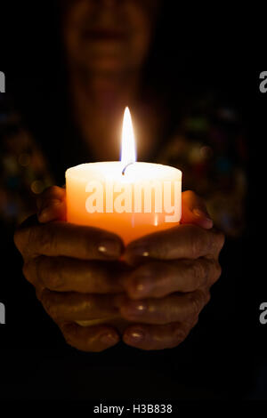 Cropped image of female fortune teller holding lit candle Stock Photo