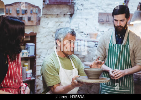 Potter discussing with colleagues Stock Photo
