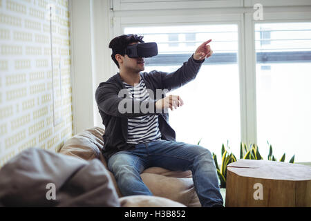 Editor gesturing while using virtual reality simulator Stock Photo