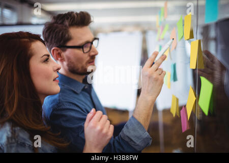 Creative business people looking at sticking notes Stock Photo