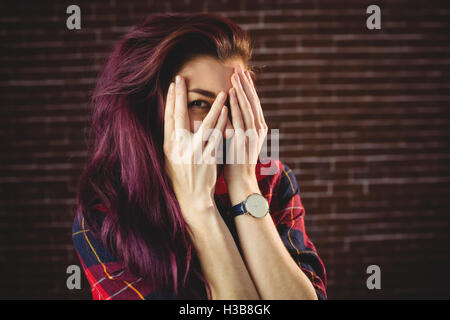 Young woman hiding face behind hands Stock Photo