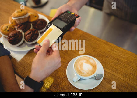 High angle view of customer paying through credit card Stock Photo