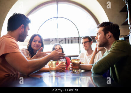 happy friends drinking beer at bar or pub Stock Photo