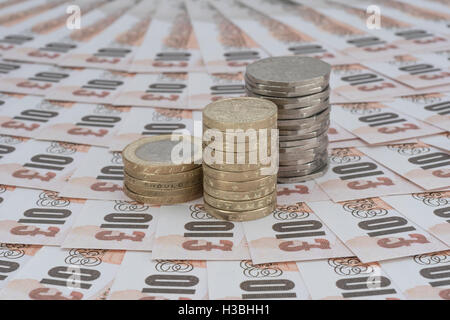 Old design £10 banknotes with 3 stacks of UK £ coins (£10 in each: £2, old style £1 & 50p) - as concept for UK currency, wages, economy and inflation Stock Photo