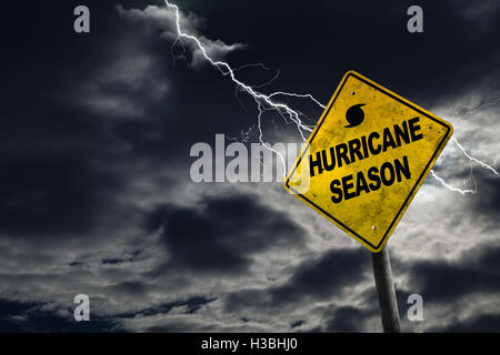 Hurricane season with symbol sign against a stormy background and copy space. Dirty and angled sign adds to the drama. Stock Photo