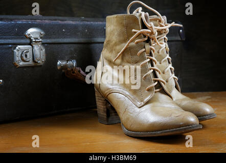 old suitcase and women's shoes closeup Stock Photo