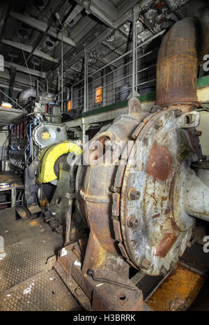 The ship's hold with diesel engine mounted on ship. Engine room on a old cargo boat ship. Stock Photo