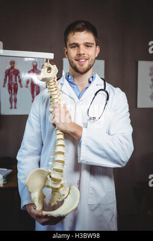 Portrait of physiotherapist holding spine model Stock Photo