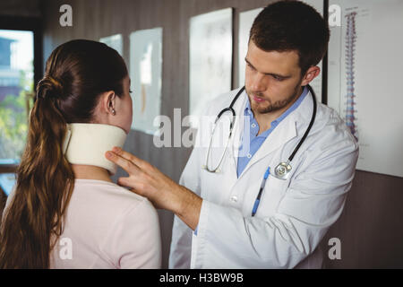 Physiotherapist examining a female patient's neck Stock Photo