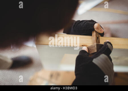 Carpenter using marking gauge on a wooden door Stock Photo