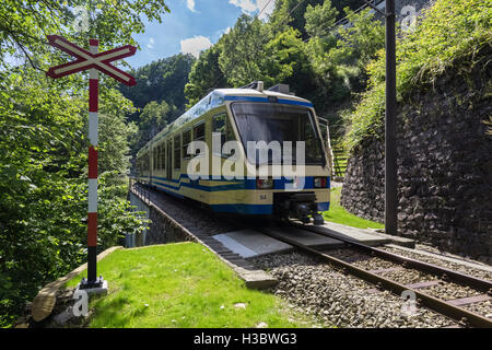 Vigezzina train passes through a rail crossing in Borgnone, Centovalli, Canton Ticino, Switzerland Stock Photo