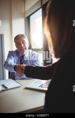 Businessman shaking hands with colleague Stock Photo