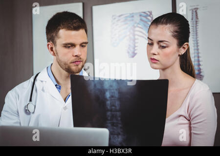 Physiotherapist explaining spine x-ray to female patient Stock Photo