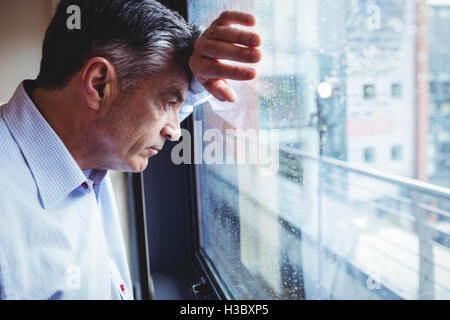Doctor looking out of window Stock Photo